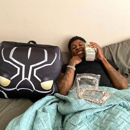 Armani Gaulden's father, Kentrell DeSean Gaulden is sleeping in the bed and flexing his diamond jweleries and money. 